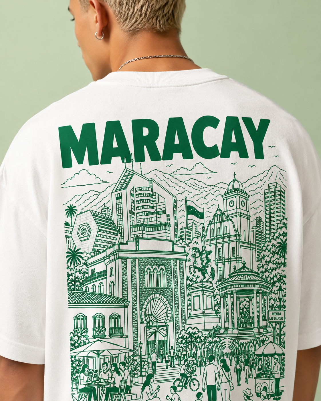 Person wearing a white t-shirt with green 'MARACAY' text and cityscape illustration on a light green background